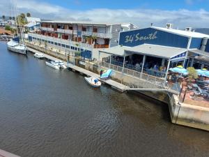 克尼斯納的住宿－Belle View @ Knysna Quays，船停靠在河边的建筑物旁边