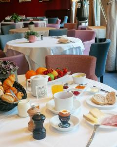 a breakfast table with breakfast foods on a table at Hôtel et Restaurant Le Regina in Le Puy-en-Velay