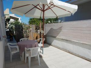 a table with an umbrella on a patio at Casa Vacanza Fiori di Maggio in Pulsano