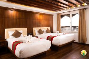 加德满都Hotel Kailash Kutee的带木镶板的房间里有两张床