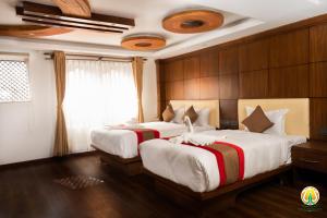 twee bedden in een kamer met houten wanden bij Hotel Kailash Kutee in Kathmandu