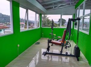 a green room with a gym with a treadmill at DACOSTEL Syariah in Karangtengah