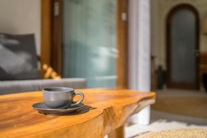 a coffee cup sitting on top of a wooden table at Nagara Boutique Hotel in Jimbaran