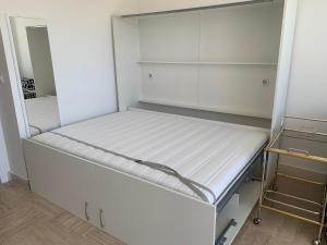 einen weißen Schrank mit einem weißen Bett darin in der Unterkunft F1 Exclusive Monaco Studio with Private Parking in Monte Carlo