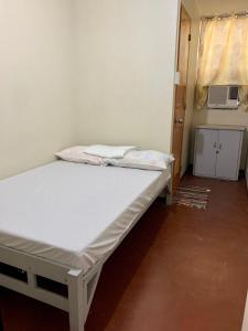 ein weißes Bett in einem Zimmer mit Fenster in der Unterkunft Mybed Dormitory in Cebu City