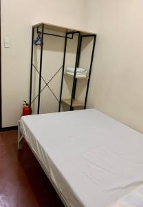 a white bed in a room with a shelf at Mybed Dormitory in Cebu City
