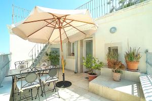 a patio with a table and an umbrella at Casa Antica Rudia in Ostuni