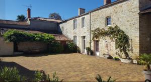 a courtyard of an old brick building with a stone driveway at L'Heureux Lay in La Réorthe