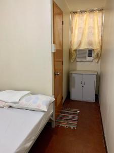 a small bedroom with a bed and a window at Mybed Dormitory in Cebu City