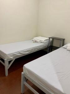 three beds in a room with white walls at Mybed Dormitory in Cebu City
