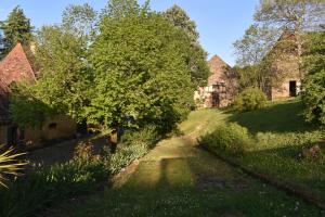 une vieille maison au milieu d'une cour dans l'établissement Gîte du Petit Bois, au Buisson de Cadouin