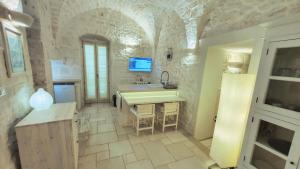 a large kitchen with a sink and a counter at Casa Antica Rudia in Ostuni
