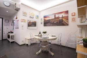 a dining room with a white table and chairs at Happy Home Bo Centro FREE PRIVATE PARKING in Bologna