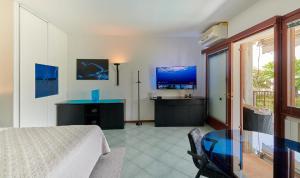a bedroom with a bed and a table and a tv at Apartments Rainer - Front Lake in Bardolino