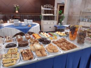 a table filled with lots of different types of pastries at Hotel Finca La Mansión in Llanes
