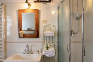 W łazience znajduje się umywalka, lustro i prysznic. w obiekcie Agriturismo Poggio Salvi w mieście Sovicille