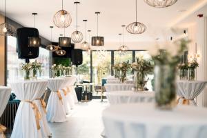 a row of tables with white chairs and flowers at Hotel Millennium by Aycon in Budva +37 photos