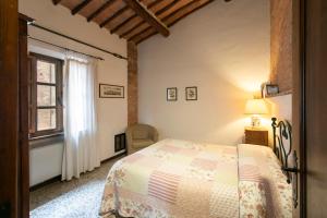 sypialnia z łóżkiem i oknem w obiekcie Agriturismo Poggio Salvi w mieście Sovicille