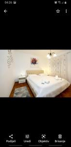 a bedroom with a large bed with a white bedspread at antonio in Bibinje