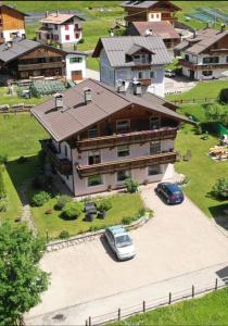 a large house with a car parked in front of it at Appartamenti Soravia in Sappada