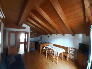 a kitchen and dining room with a table and chairs at Appartamenti Soravia in Sappada