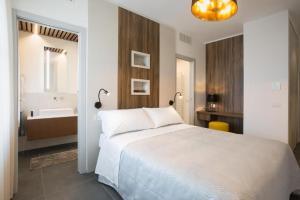 a bedroom with a large white bed and a bathroom at Enjoy Garden - Flavio Baracchini 9 in Milan
