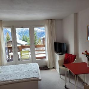 a hotel room with a bed and a desk and a television at Residence Edelweiss in Bellwald