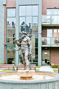 a statue of a man with a spear in front of a building at The Best Stay Central Apartment Gdansk in Gdańsk
