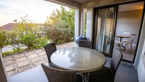 un tavolo e sedie su un balcone con vista di Modern self-catering apartment in a secure estate a Plettenberg Bay
