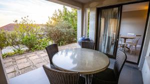 a table and chairs on a balcony with a view at Modern self-catering apartment in a secure estate in Plettenberg Bay