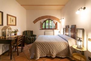 sypialnia z łóżkiem, biurkiem i krzesłem w obiekcie Agriturismo Poggio Salvi w mieście Sovicille +37 zdjęć
