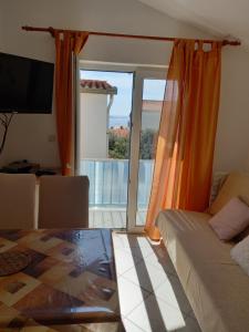 a living room with a bed and a glass table at Apartments Dvorski in Mandre