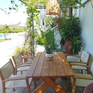 a wooden table and chairs on a patio with plants at Kassiani Studios in Plakias