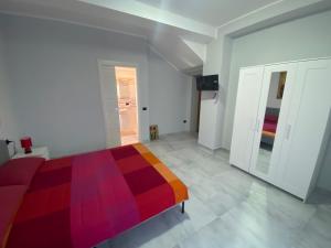 ein Schlafzimmer mit einem bunten Bett in einem weißen Zimmer in der Unterkunft B&B Santa Colomba in Benevento