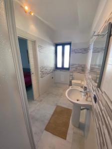 a white bathroom with a sink and a mirror at B&B Santa Colomba in Benevento