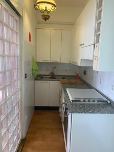 una cocina con armarios blancos y fregadero en Casa Elena, en Arezzo