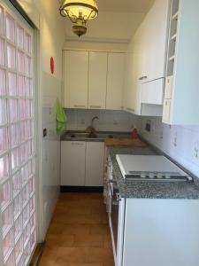 a kitchen with white cabinets and a sink at Casa Elena in Arezzo +5 photos