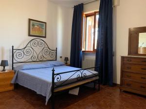 a bedroom with a bed and a dresser and a window at Casa Elena in Arezzo
