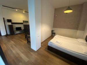 a bedroom with a bed and a living room at Apartment In Batumi MGZAVREBI in Batumi