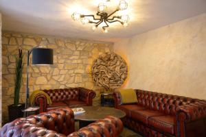 a living room with leather couches and a stone wall at Ferienwohnung Altschloss in Eppenbrunn