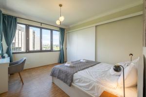 een slaapkamer met een bed, een bureau en een raam bij Sunrise City View Apt / NDK in Sofia