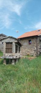 een oud stenen gebouw met een vogel die er boven vliegt bij Casa do Xurés in Maus de Salas