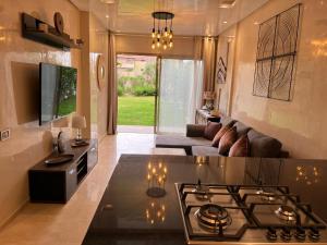 a living room with a stove and a couch at Appartement de Luxe -Prestigia Marrakech Golf City in Marrakech