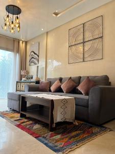 a living room with a couch and a coffee table at Appartement de Luxe -Prestigia Marrakech Golf City in Marrakech