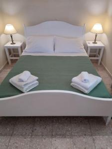 a large white bed with two nightstands and towels on it at Authentic Country House in Zakynthos in Ambelókipoi