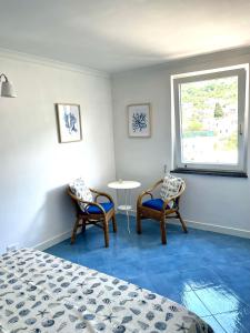 アナカプリにあるAttico Panoramicoのベッドルーム1室(椅子2脚、テーブル1台、窓付)