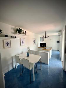 cocina y comedor con mesa blanca y sillas en Attico Panoramico, en Anacapri