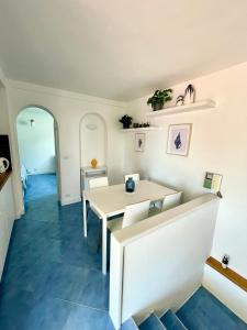 ein Esszimmer mit einem Tisch und blauem Boden in der Unterkunft Attico Panoramico in Anacapri