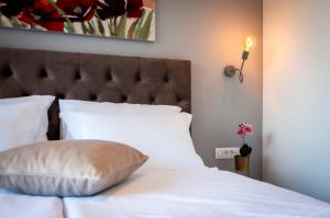 a bedroom with a white bed with a large headboard at Boutique Residence Arion in Rovinj