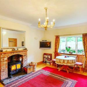 a living room with a fireplace and a table at Pinetree Cottage, dog friendly, Holiday let, Callander Invertrossachs in Callander